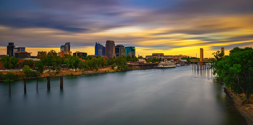 Photo of Sacramento skyline at sunset, featuring Sacramento river and Tower Bridge